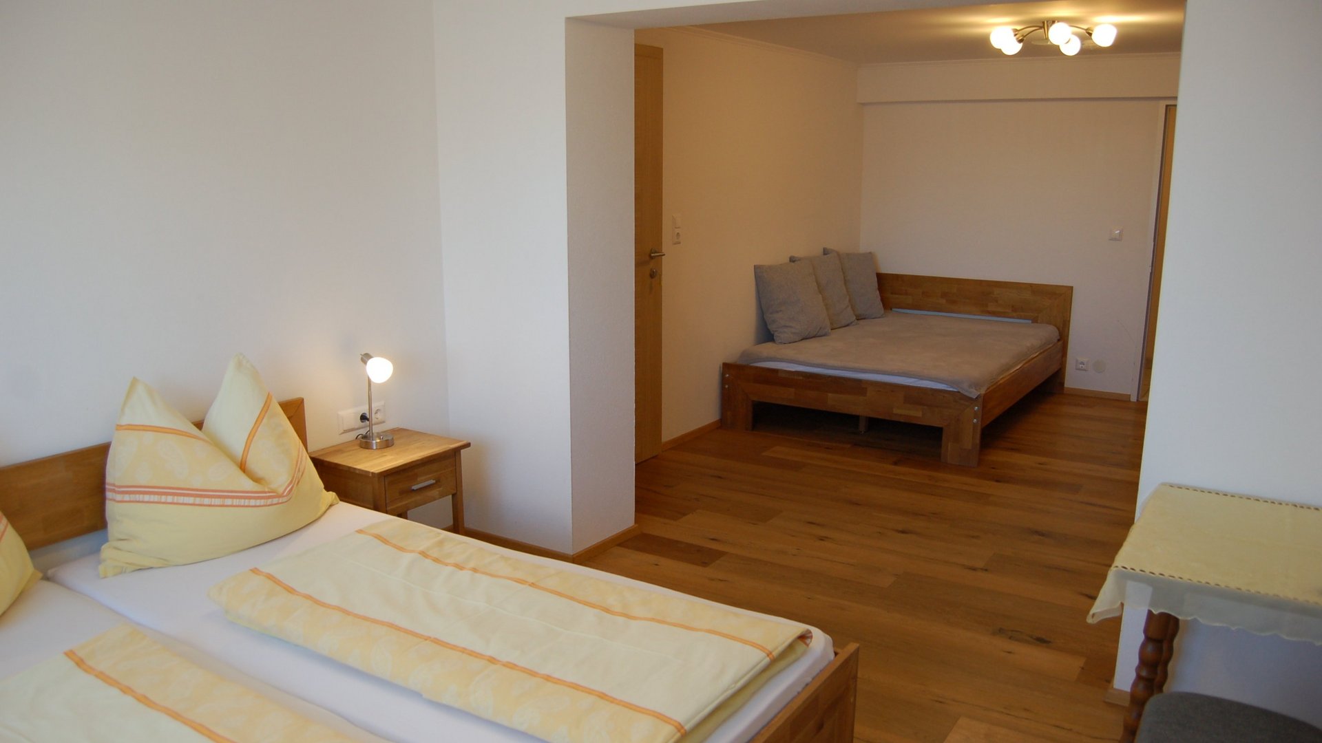 Doppelzimmer mit zwei Betten und Holz Möbeln im Hotelzimmer, helle Farbtöne und gemütliches Design.