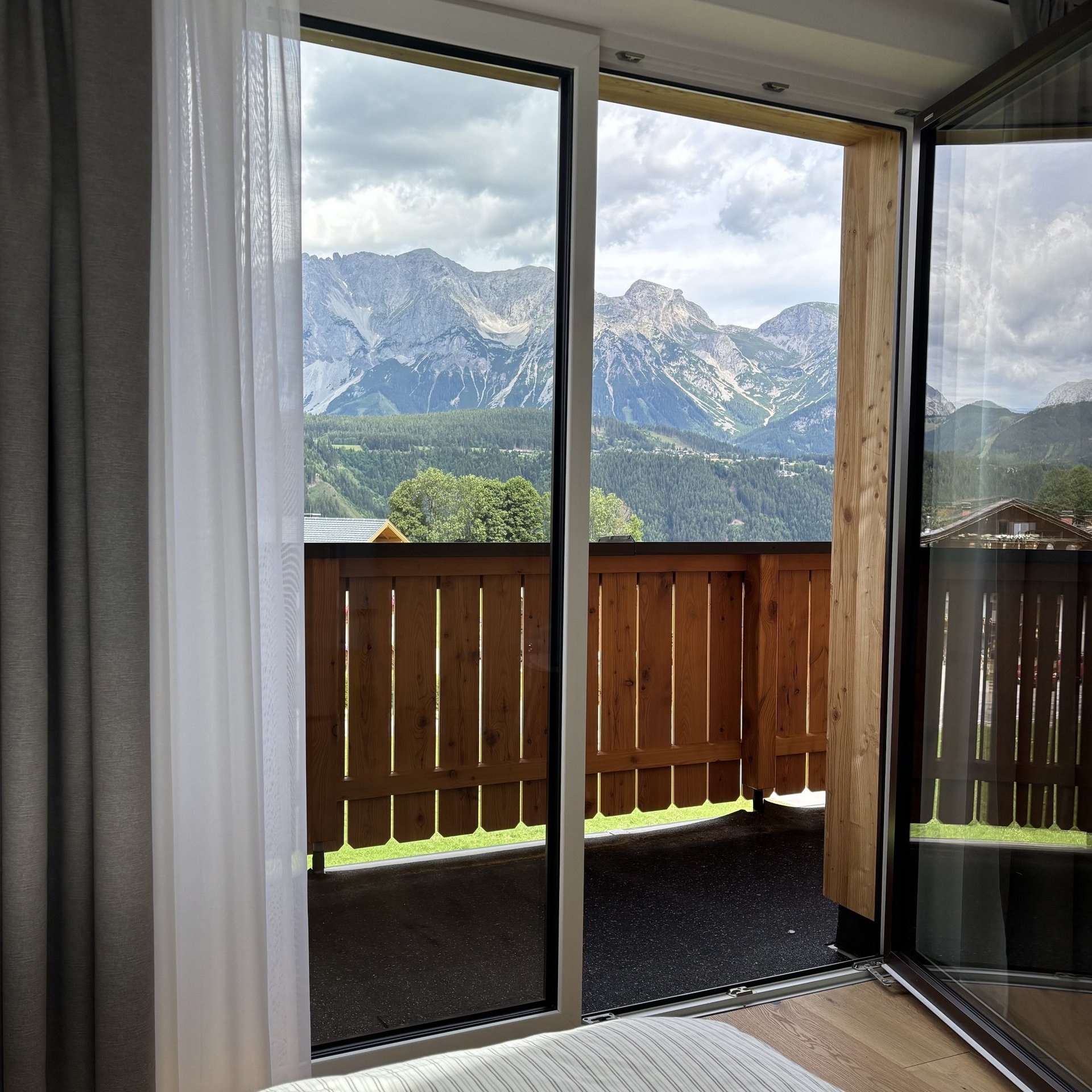 Bergblick vom Hotelzimmer Hotelzimmer mit Balkon und Blick auf die Berge, offenes Fenster, modernes Design