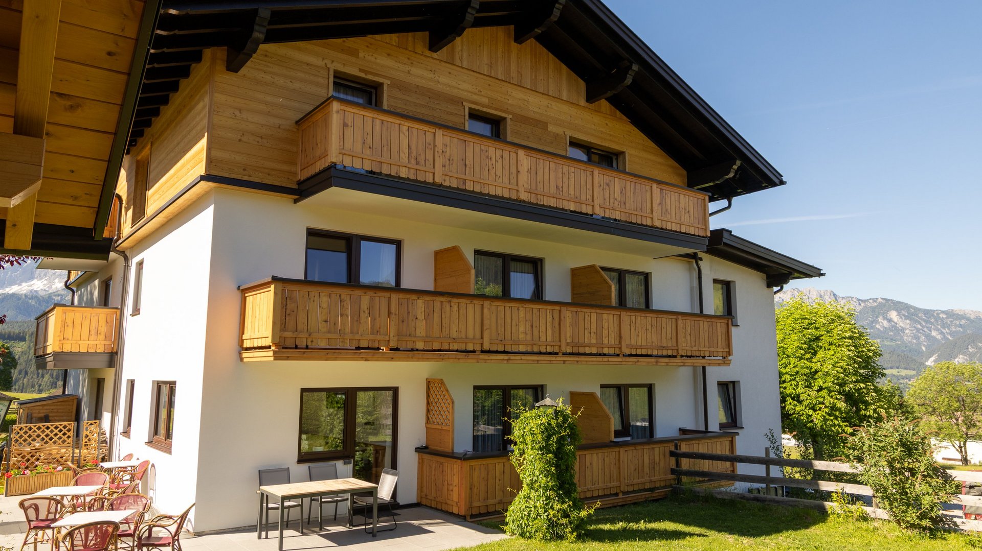 Modern Mountain Lodge with Scenic Views Contemporary mountain lodge featuring wooden balconies and outdoor seating areas surrounded by mountains