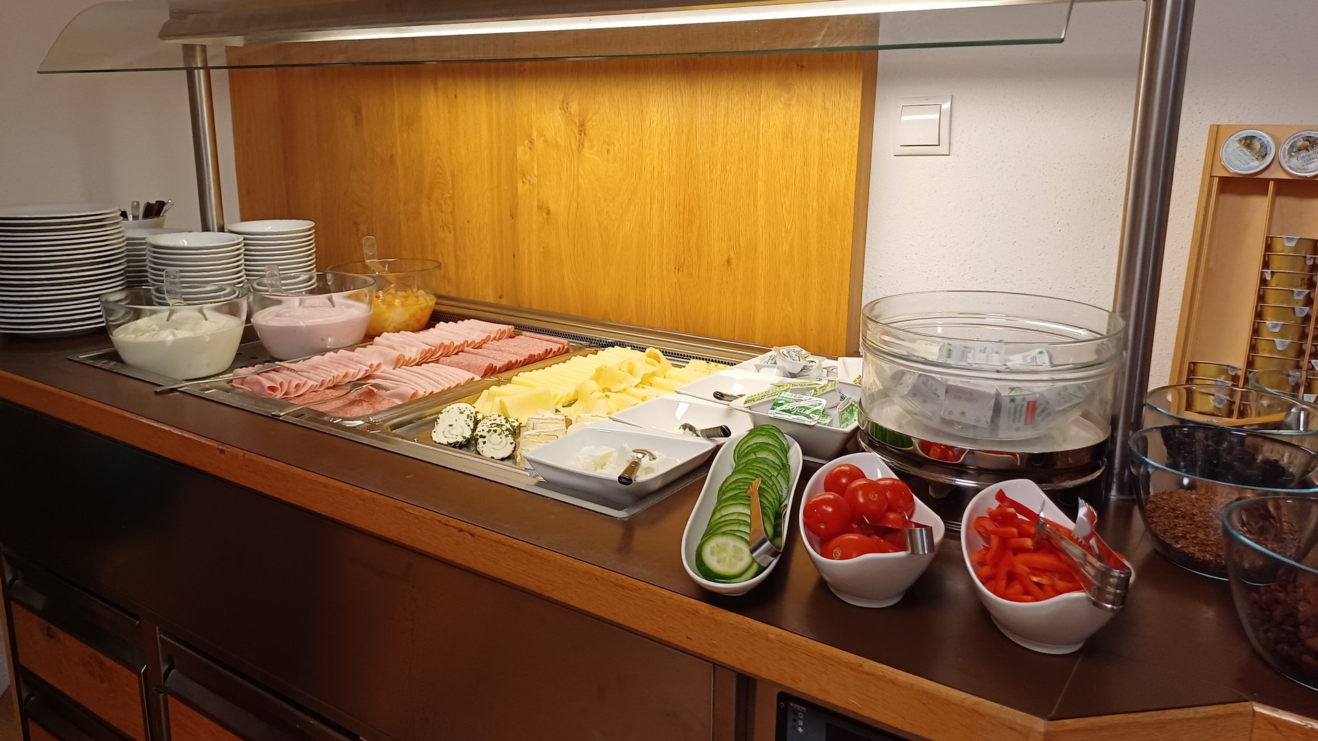 Buffet mit Aufschnitt, Käse, Gemüse und Beilagen in ansprechender Anordnung auf einem Tisch.
