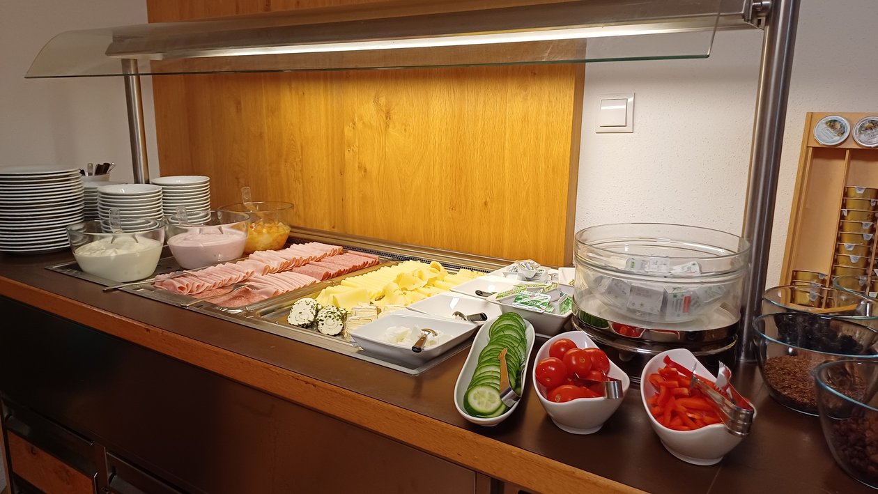 Buffet mit Aufschnitt, Käse, Gemüse und Beilagen in ansprechender Anordnung auf einem Tisch.