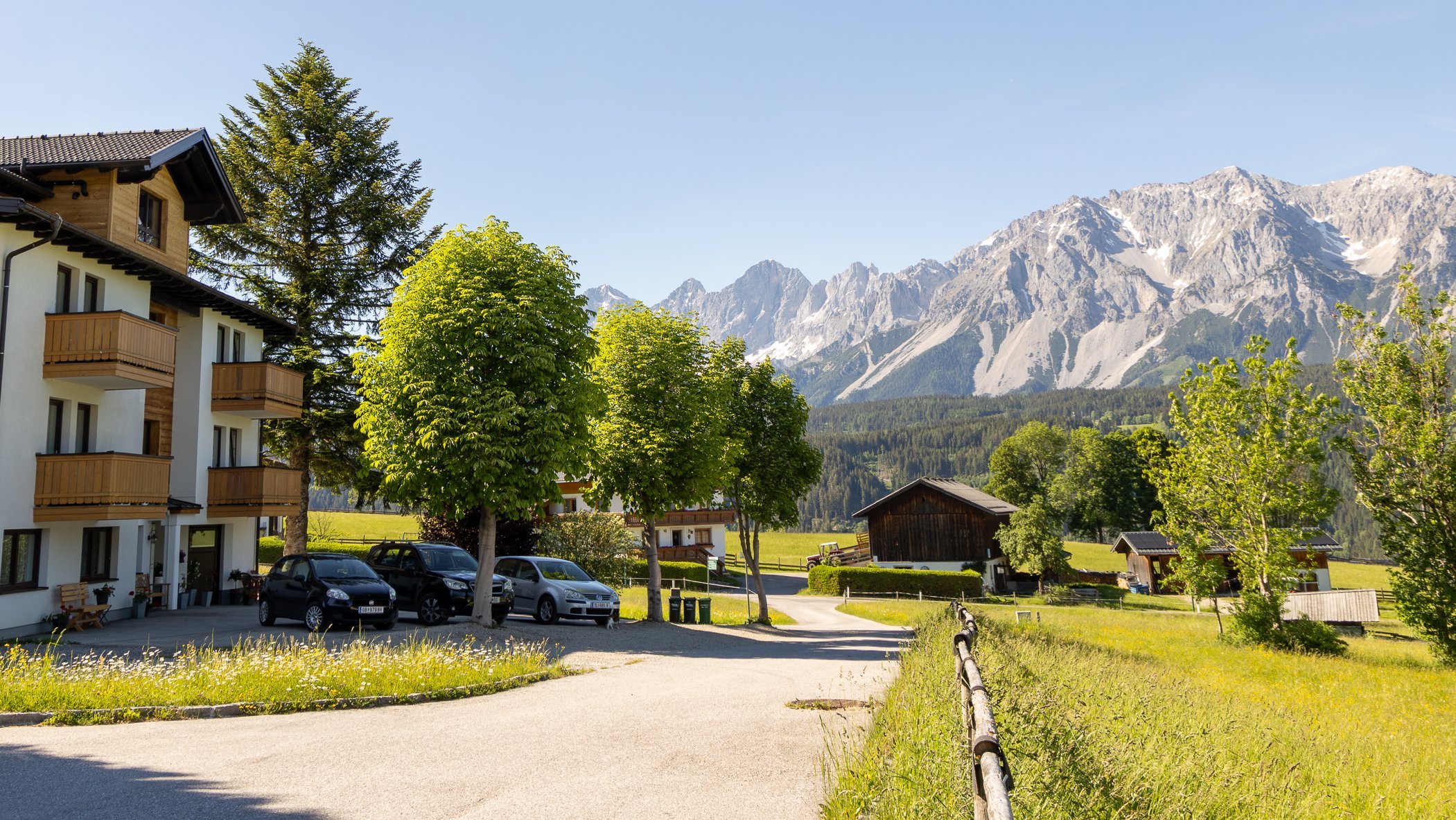 Hotelgebäude in einer malerischen Berglandschaft unter klarem blauen Himmel mit hohen Bergen im Hintergrund