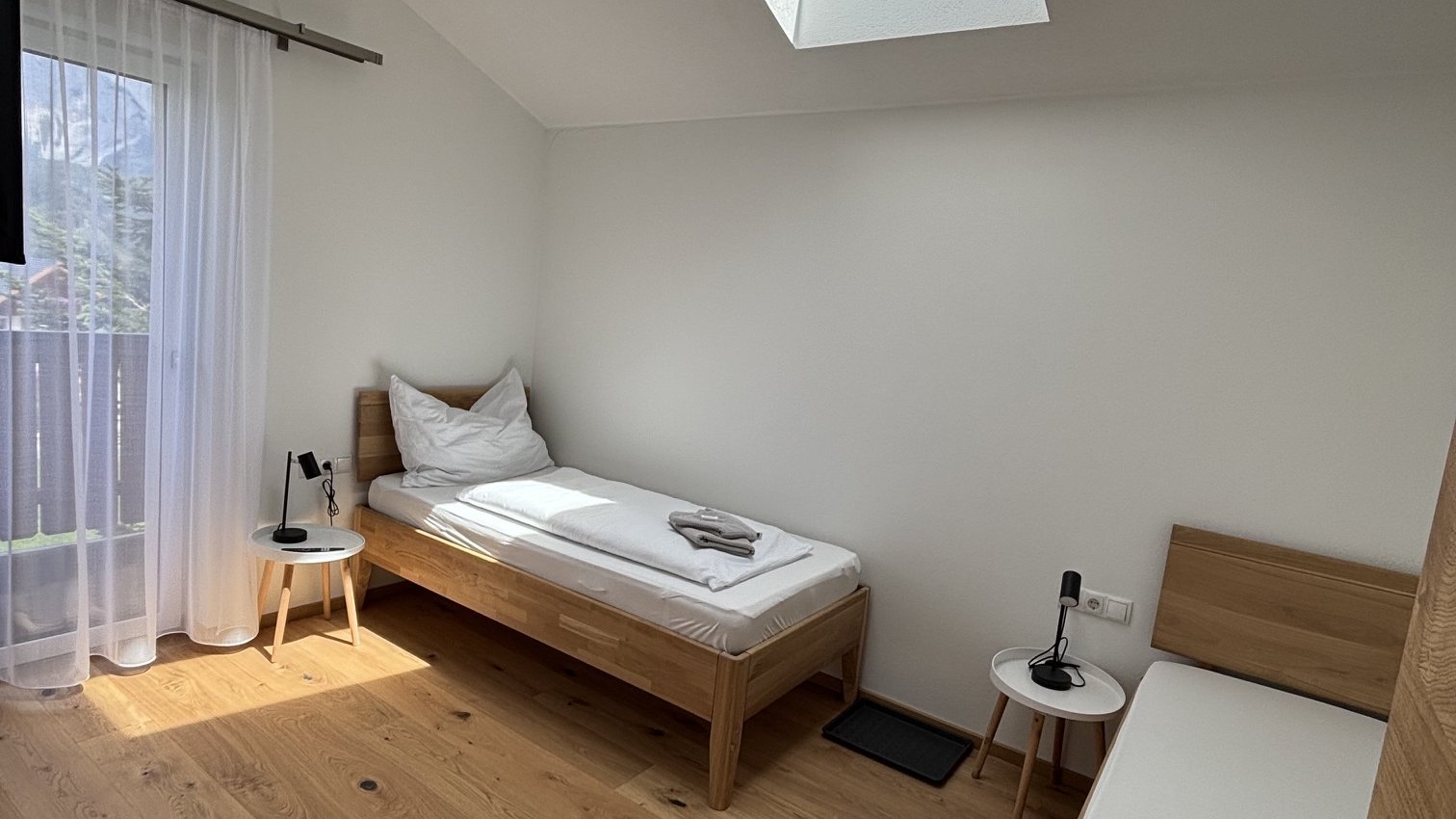 Modernes Schlafzimmer mit natürlichem Licht Zwei Einzelbetten in einem modernen Schlafzimmer mit großen Fenstern und minimalistischem Design