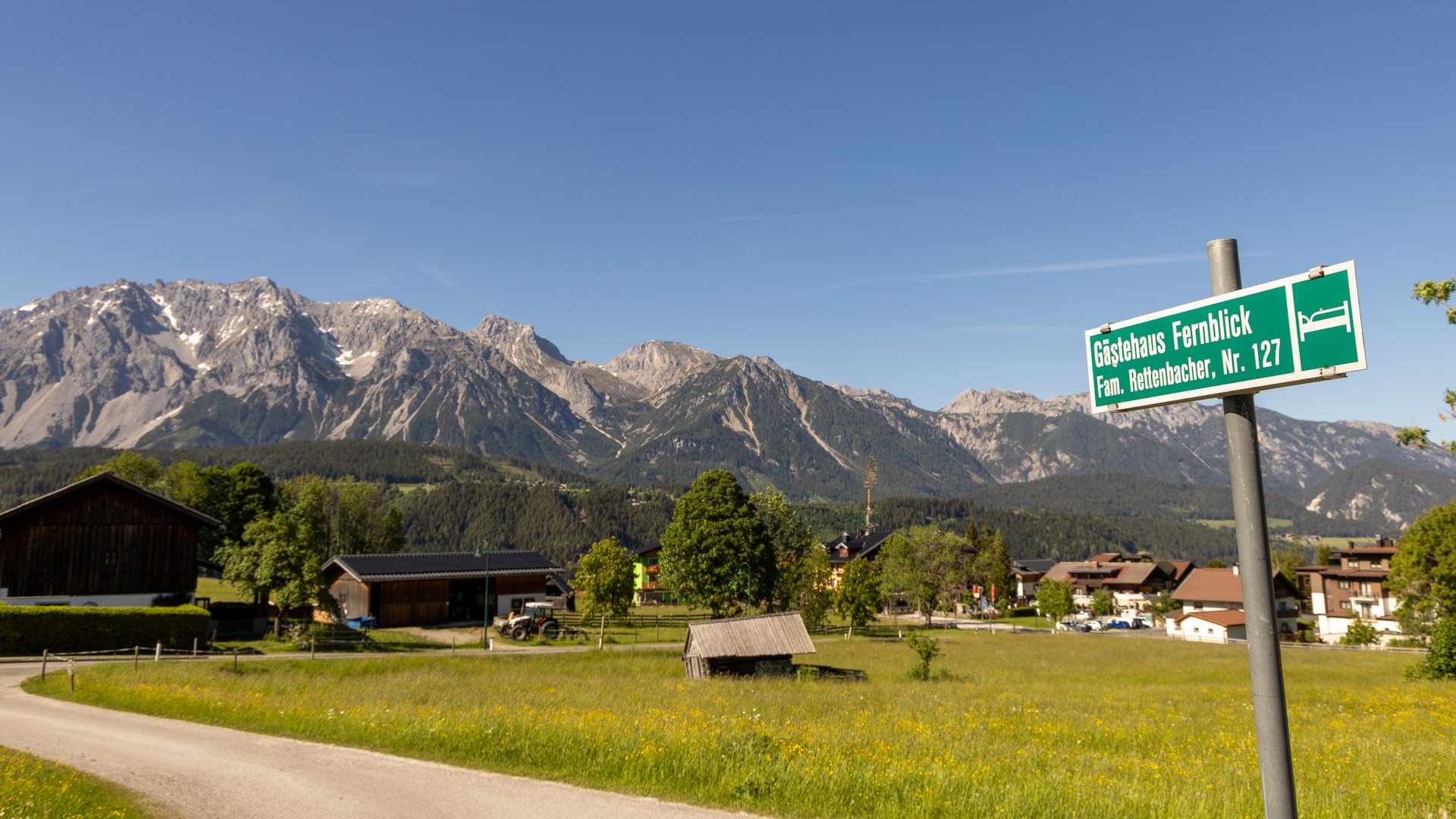 Scenic Mountain Landscape with Signpost A signpost indicating directions in a countryside landscape with mountains in the background
